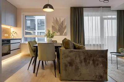 a kitchen and living room with a table and chairs at Lake Town Apartment in Vilnius