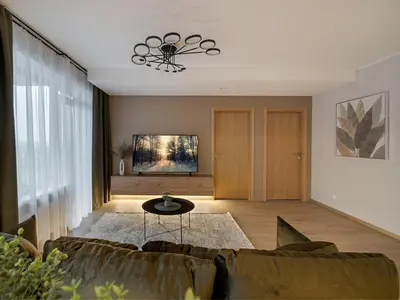 a living room with a couch and a table at Lake Town Apartment in Vilnius