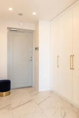 a room with white cabinets and a door and a chair at The Zen Den Apartment in Uzupis in Vilnius