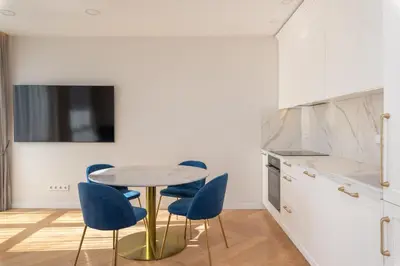 a kitchen with a round table and blue chairs at The Zen Den Apartment in Uzupis in Vilnius