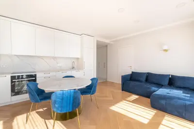 a living room with a blue couch and a table at The Zen Den Apartment in Uzupis in Vilnius