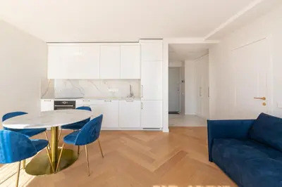 a living room with a table and blue chairs at The Zen Den Apartment in Uzupis in Vilnius