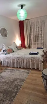 a bedroom with a large bed and a green light at Šiauliai Central Vytauto Apartment in Šiauliai