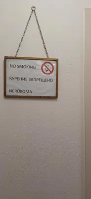 a no smoking sign hanging on a wall at Šiauliai Central Vytauto Apartment in Šiauliai