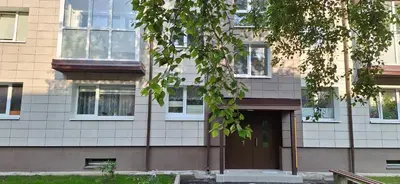 a building with a brown door and windows at Šiauliai Central Vytauto Apartment in Šiauliai