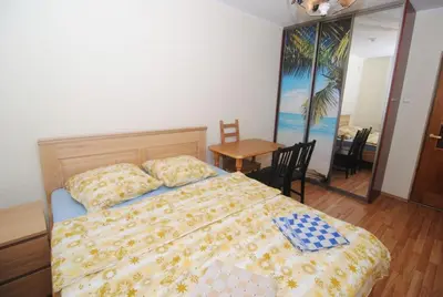 a bedroom with a bed and a table and a dining room at Rodante Apartments in Druskininkai