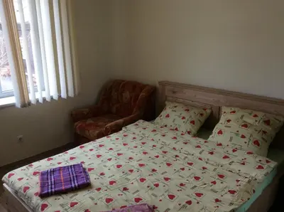 a bedroom with a bed and a chair and a bedspread at Rodante Apartments in Druskininkai
