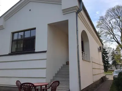 a building with a table and chairs in front of it at Rodante Apartments in Druskininkai