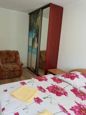 a bedroom with a bed with pink flowers on it at Rodante Apartments in Druskininkai