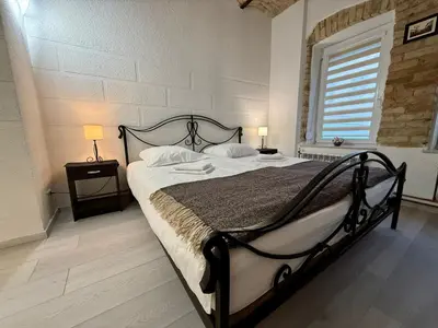 a bedroom with a large bed in a room with a window at Šopeno Old Town Apartments in Vilnius