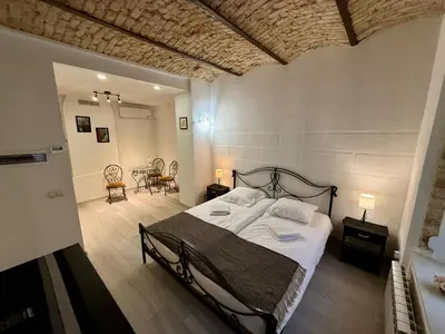 a bedroom with a bed and a table and chairs at Šopeno Old Town Apartments in Vilnius