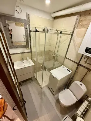 a bathroom with a shower and a toilet and a sink at Šopeno Old Town Apartments in Vilnius