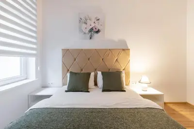 a bedroom with a large bed with a headboard at Cosy Central Apartments by Reside Baltic in Vilnius