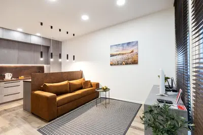 a living room with a couch and a kitchen at Cosy Central Apartments by Reside Baltic in Vilnius