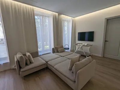 a living room with a couch and some windows at Rambynas R36 in Panevėžys