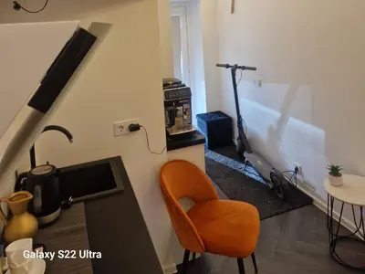 a living room with a television and a chair at Kaunas Studios - RentA Studio 16 in Kaunas