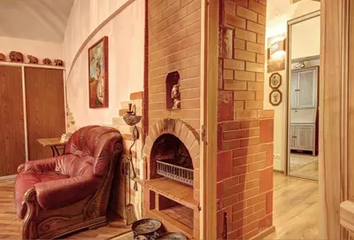 a living room with a brick fireplace and a chair at Sofijos apartamentai Old Town in Vilnius