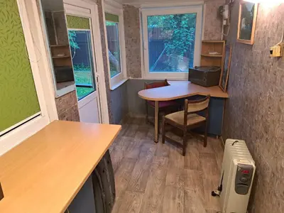 a small room with a table and a desk and windows at Patrimpo in Magūnai