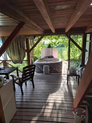 a room with a bed on a wooden deck at Patrimpo in Magūnai