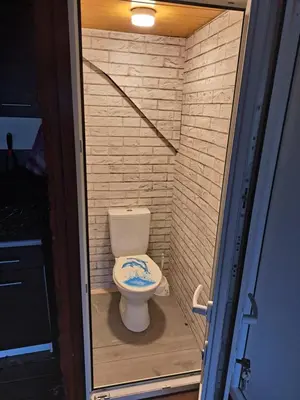 a small bathroom with a toilet in a brick wall at Patrimpo in Magūnai
