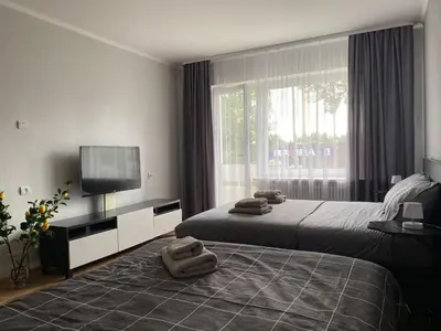a bedroom with two beds and a flat screen tv at Quiet Comfortable Stay - Energetiku g 32, Visaginas in Visaginas