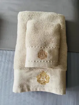 a white towel with a gold design on it at Quiet Comfortable Stay - Energetiku g 32, Visaginas in Visaginas