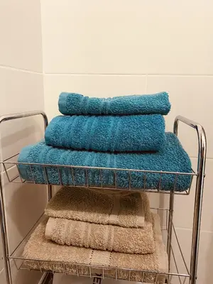 a pile of towels on a towel rack in a bathroom at Quiet Comfortable Stay - Energetiku g 32, Visaginas in Visaginas