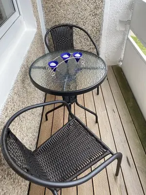 a glass table and a chair on a porch at Quiet Comfortable Stay - Energetiku g 32, Visaginas in Visaginas