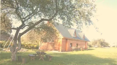 a log cabin with a picnic table and a tree at Leon's farmstead in the countryside, Sauna and Jacuzzi for 16-23 people in Užuperkasis