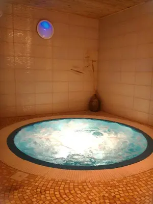 a jacuzzi tub in a bathroom with a blue at Leon's farmstead in the countryside, Sauna and Jacuzzi for 16-23 people in Užuperkasis