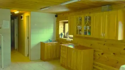 a kitchen with wooden cabinets and a sink at Leon's farmstead in the countryside, Sauna and Jacuzzi for 16-23 people in Užuperkasis