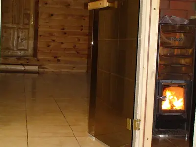 a fire burns in a fireplace in a room at Leon's farmstead in the countryside, Sauna and Jacuzzi for 16-23 people in Užuperkasis