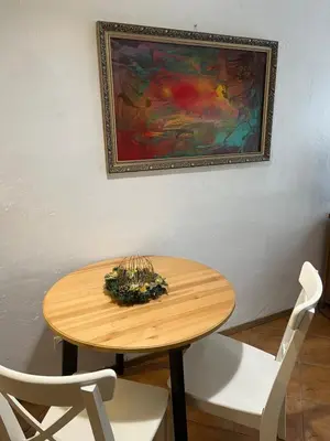 a wooden table with two white chairs and a painting at Old Town Loft in Vilnius