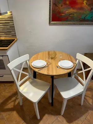 a wooden table and two chairs with plates and wine glasses at Old Town Loft in Vilnius