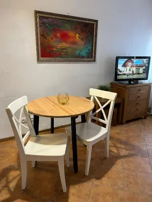 a wooden table and two chairs and a television at Old Town Loft in Vilnius