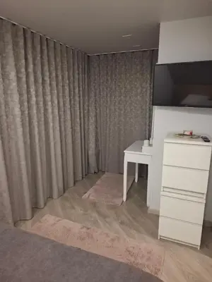 a living room with a desk and a curtain at Šermukšniai in Rokiškis