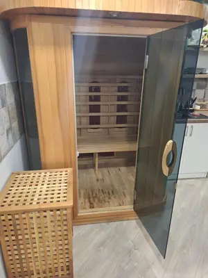 a wooden cabinet with a glass door and a bench at Šermukšniai in Rokiškis