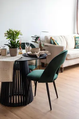 a table and chairs in a living room with a couch at Cozy 1BD with Bathtub Close to Old Town in Vilnius