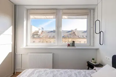 a bedroom with a window with a view of a city at Cozy 1BD with Bathtub Close to Old Town in Vilnius