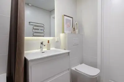a white bathroom with a sink and a toilet at Cozy 1BD with Bathtub Close to Old Town in Vilnius