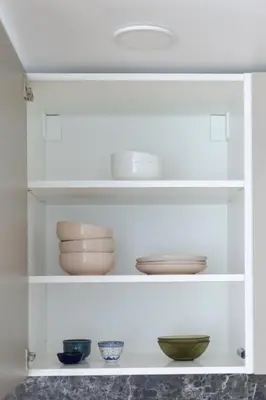 a white shelf with bowls and plates on it at Cozy 1BD with Bathtub Close to Old Town in Vilnius