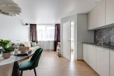 a kitchen and living room with a table and a couch at Cozy 1BD with Bathtub Close to Old Town in Vilnius