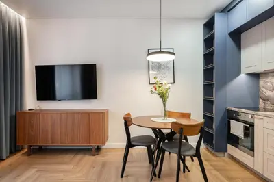 a dining room with a table and chairs and a tv at Serenity Space in Vilnius by Reside Baltic in Vilnius