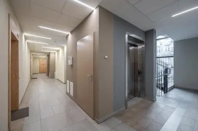 a hallway of an office building with doors and tile floors at Serenity Space in Vilnius by Reside Baltic in Vilnius