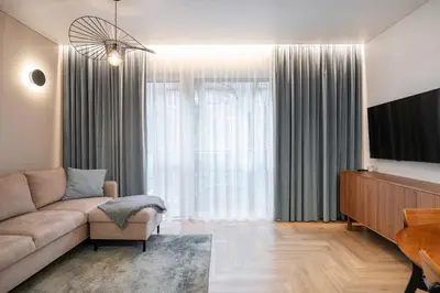 a living room with a couch and a large window at Serenity Space in Vilnius by Reside Baltic in Vilnius