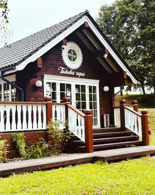 a small log cabin with a white fence and stairs at Sodyba Barracuda in Kupščiai