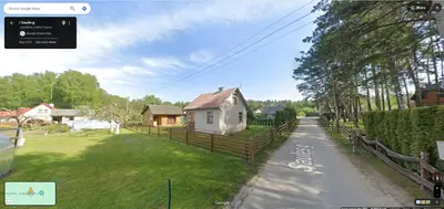 a house on the side of a road with a fence at Namelis Saulės gatvėje prie Siesarties ežero in Molėtai