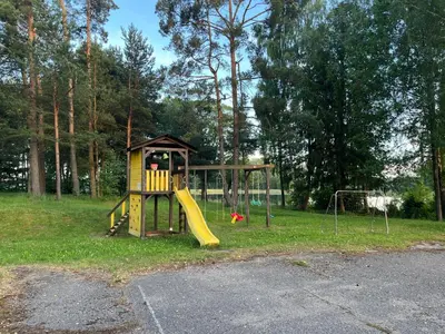 a small playground with a slide and a swing at Namelis Saulės gatvėje prie Siesarties ežero in Molėtai
