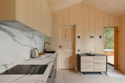 a kitchen with marble countertops and wooden walls at Dubinga River Valley House & SPA - FREE sauna in Kabakelis