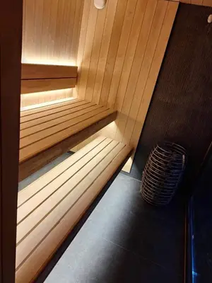 a wooden sauna with a bench in a room at Dubinga River Valley House & SPA - FREE sauna in Kabakelis